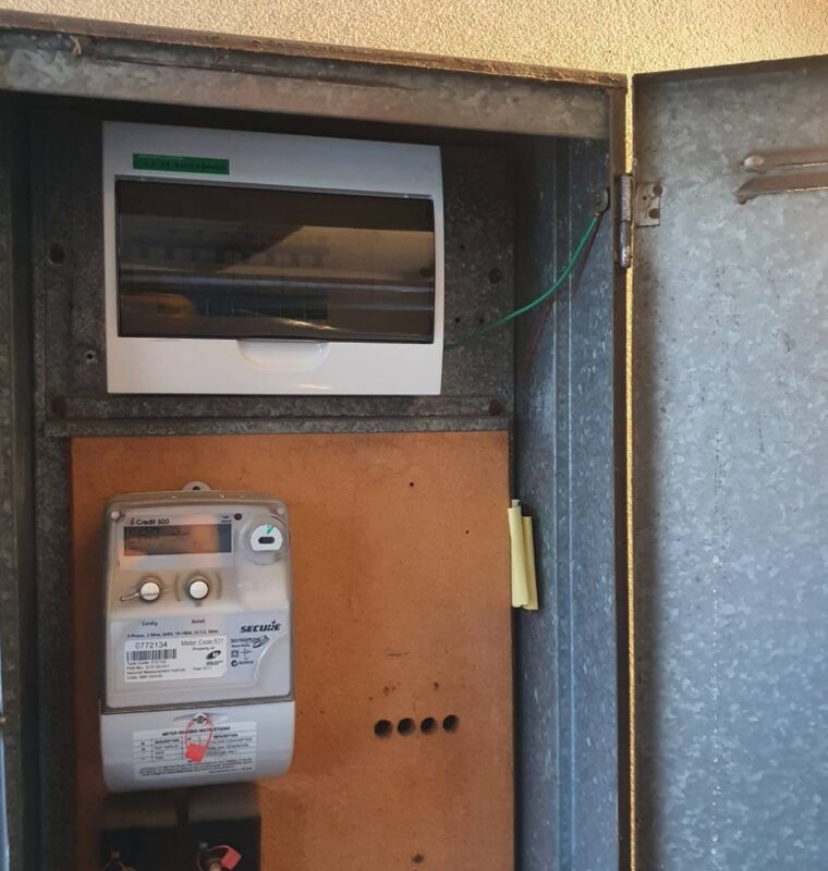 Switchboard after: a new enclosed board with circuit breakers above the meter