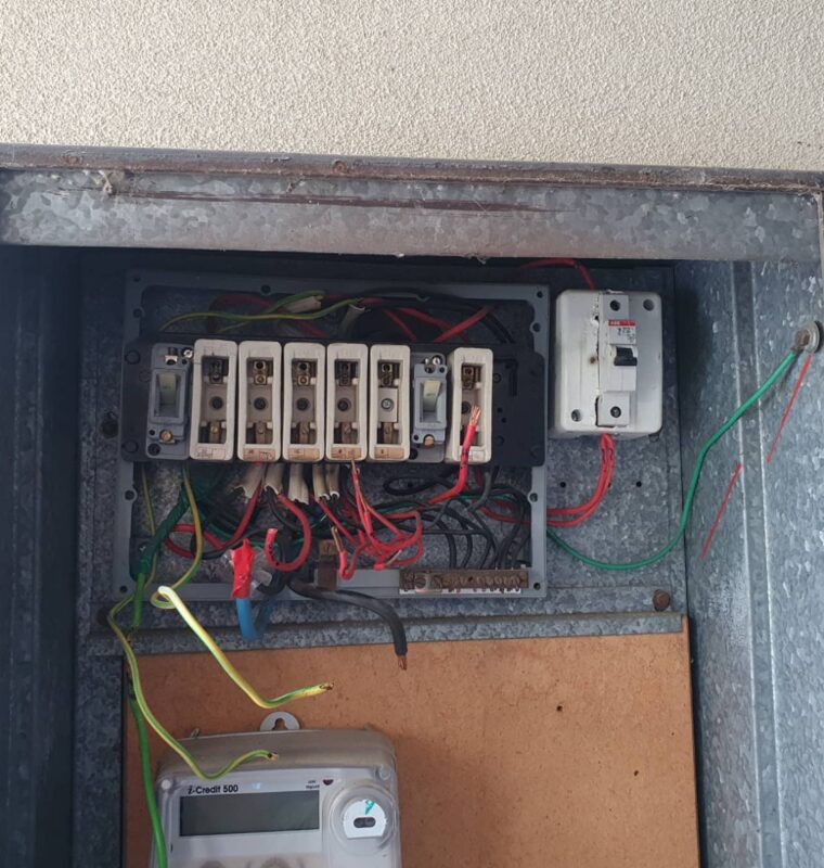 Switchboard before: old ceramic fuses and loose wiring in the meter box